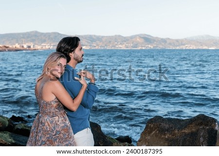 young couple in love posing with the sea in the background