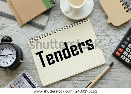 TENDERS text on a notepad with a spiral. cup of coffee