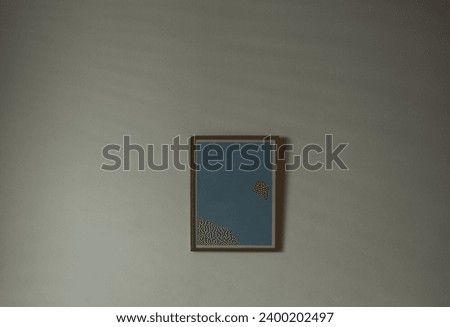 empty Poster hanging on white sunny wall background. living room interior in beige. light device. empty mock up room. wall. Blank wooden vertical frame. mockup gray backdrop. Natural light. shadow 