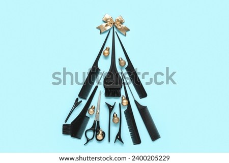 Christmas tree made of hairdresser's tools and decorations on color background
