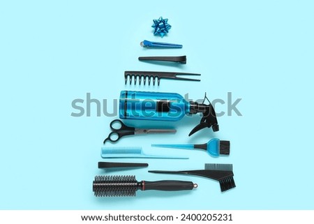 Beautiful Christmas tree made of hairdresser's tools and decorations on color background