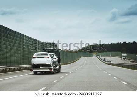 Tow truck with a broken car on a road. Tow truck transporting car on the highway. Car service transportation concept. Roadside Rescue. Royalty-Free Stock Photo #2400211227