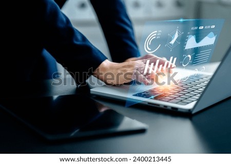 Businesswomen analyze chart data business on a visual screen dashboard laptop, technology devices and screens visible in the background, financial planning, market research, and the stock market.
