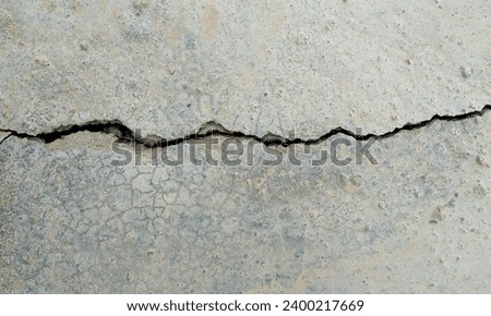Abstract Rough Dry paint is peeling off the building wall.Close-up. Badly fixed building facade wall covered with cracks in stucco and paint. Missing patch of paint in the middle; crack with flappy. Royalty-Free Stock Photo #2400217669