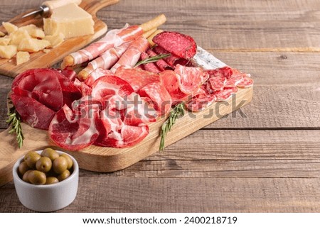 Charcuterie board. Antipasti appetizers of meat platter with salami, prosciutto crudo or jamon and olives. Royalty-Free Stock Photo #2400218719