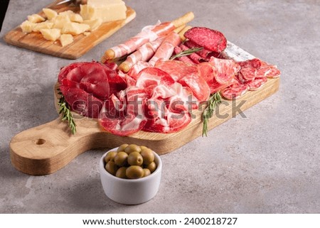 Charcuterie board. Antipasti appetizers of meat platter with salami, prosciutto crudo or jamon and olives. Royalty-Free Stock Photo #2400218727
