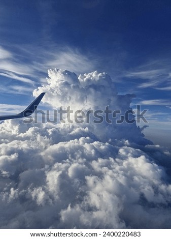 A huge and thick cloud I saw from plane window. Big cloud on the sky. This is the biggest cloud group I have ever seen. Beautiful white cloud captured from the plane.  Royalty-Free Stock Photo #2400220483