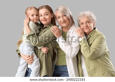 Little girl with her family hugging on light background Royalty-Free Stock Photo #2400222181