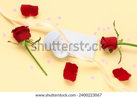 Composition with engagement ring and rose flowers on yellow background. Valentine's day celebration