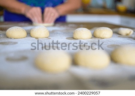 Homemade pastries dusted with flour on a linen cloth in a normal household kitchen