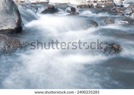 close up of water flowing over cobblestone in river