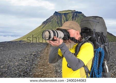 tourist photographer with a backpack photographs the beauty of nature in the mountains