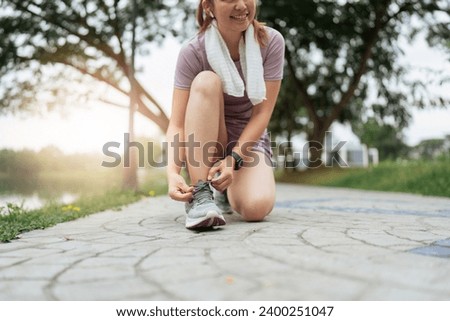 Active morning. Close up photo of woman in sport clothes tying shoelaces before running