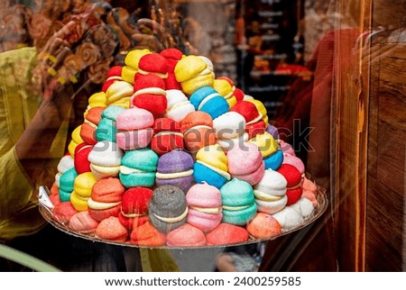 Multi-colored marshmallows in the form of small burgers lie on a tray in a store Royalty-Free Stock Photo #2400259585