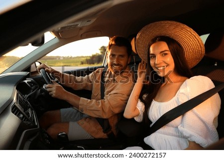 Happy couple enjoying trip together by car