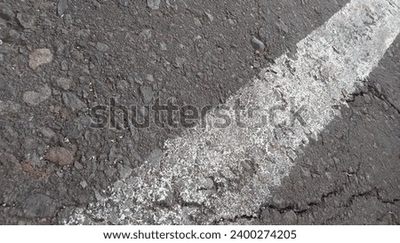 Grey asphalt with white lines. Rough cement road surface. Cracked asphalt road background.