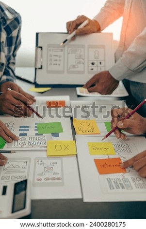 UX developers or company employees design user interfaces or UI prototypes for mobile applications or website software that display the software on sm Royalty-Free Stock Photo #2400280175