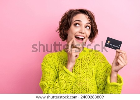 Photo young girl touch cheek admire looking empty space dreaming holding new premium customer debit card isolated on pink color background