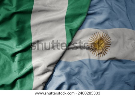 big waving national colorful flag of argentina and national flag of nigeria . macro