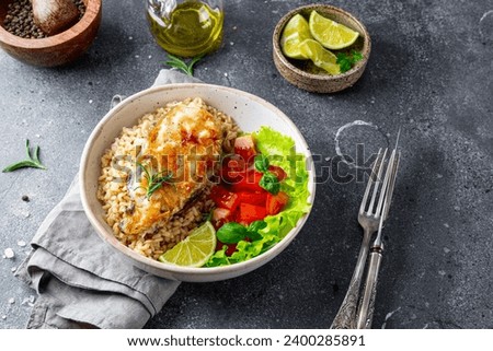 Fried catfish steak with rice and vegetable salad on a gray background. High quality photo Royalty-Free Stock Photo #2400285891