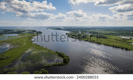 Panoramic aerial view of the Volkhov River and Lake Ilmen near Veliky Novgorod, natural attractions of Russia. Orthodox monastery on the river bank Royalty-Free Stock Photo #2400288031