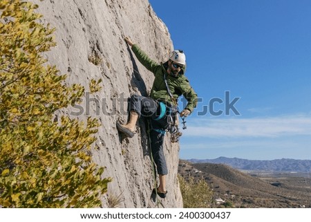 Male climber picking gear on waist Royalty-Free Stock Photo #2400300437