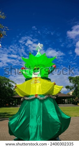 cute christmas tree character green and yellow on a blue sky background