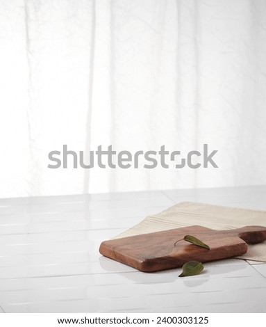 White, sunlit curtains in the kitchen and wooden cutting boards on marble floors. An empty platform for display cosmetic products, food and props Royalty-Free Stock Photo #2400303125