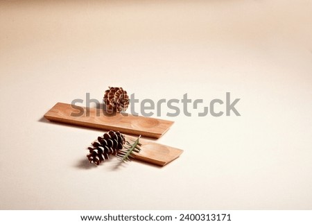 wooden plates and pine cones on brown paper. An empty platform for display cosmetic products, food and props Royalty-Free Stock Photo #2400313171