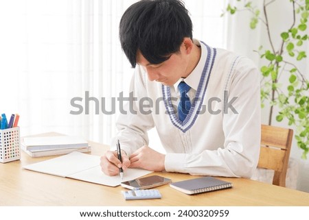 Asian high school boy studying in the living room