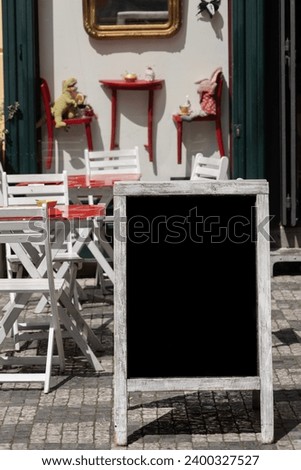 chalkboard, side view empty or blank restaurant menu blackboard on street over chair and tables of a cafe. black menu chalkboard mockup, menu board template. cafe or restaurant concept background