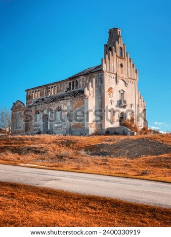 view to abandoned cathedra with road under blue sky in autumn tone