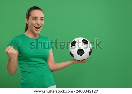 Happy fan with soccer ball celebrating on green background, space for text
