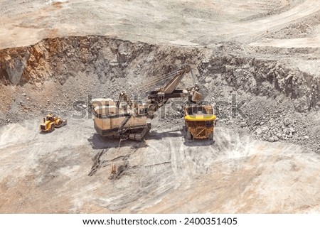 Electric rope shovel loading a dump truck at a copper mine in Peru Royalty-Free Stock Photo #2400351405