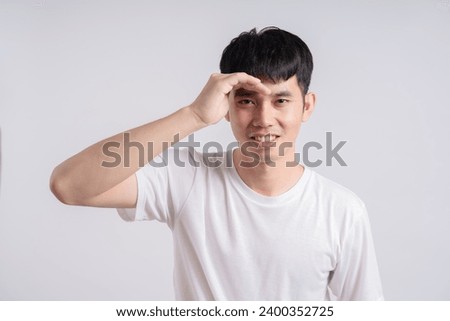 Funny obvious peeking Asian man in white t-shirt isolated on white background.