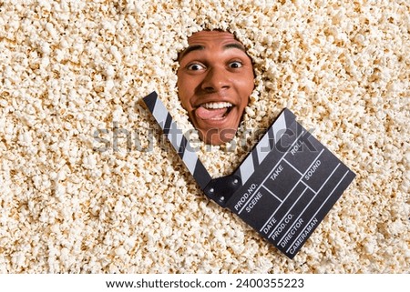Photo of playful guy enjoy new comedy film in cinema full with pop corn isolated