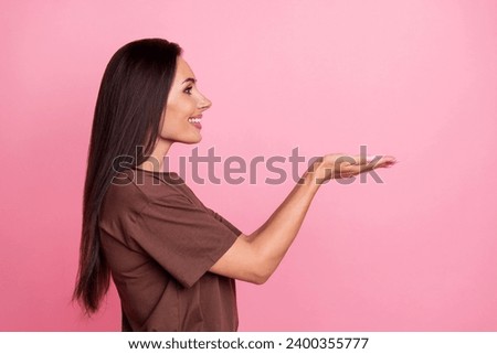 Profile photo of gorgeous positive person toothy smile look arms hold demonstrate empty space isolated on pink color background