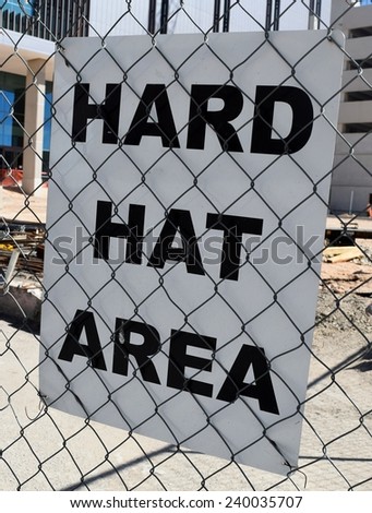 Hard Hat Area Construction sign behind a chain link fence