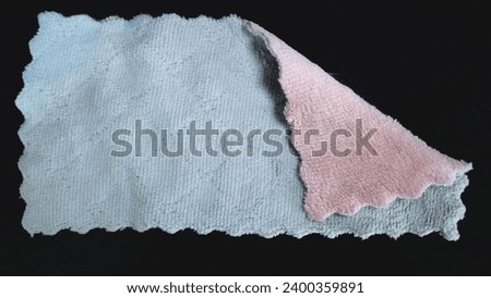 Light blue cleaning cloth with a towel-like texture isolated on a black background.