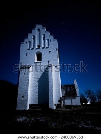 Beautiful picture of a danish church at night with a very clear sky full of stars.