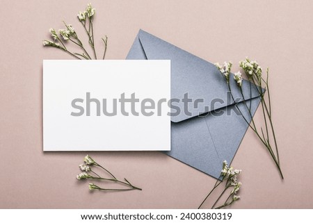 Gray envelope with flowers on a brown background. Postcard, layout. Royalty-Free Stock Photo #2400380319