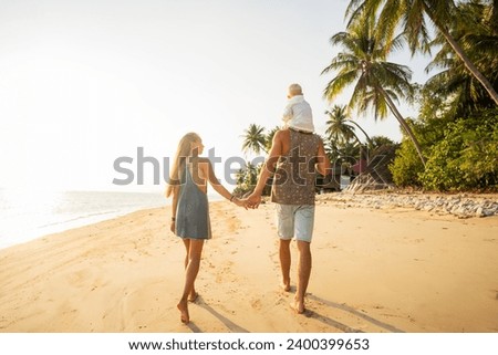 Happy asian family jumping together on the beach in holiday on tropical beach. Silhouette of the family holding hands enjoying the sunset on the beach.Happy family travel and vacations concept.