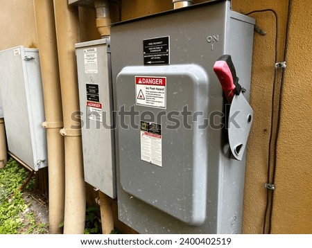 An industrial electrical disconnect panel on the outside of a building. Royalty-Free Stock Photo #2400402519