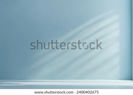 Minimalistic abstract light blue background with shadow and light from windows on the wall, product presentation concept.