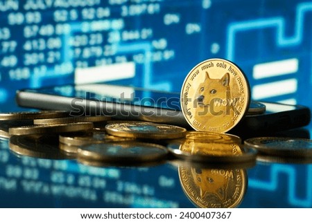Close-up of dogecoin cryptocurrency with blurred background of stock charts in blue color Royalty-Free Stock Photo #2400407367