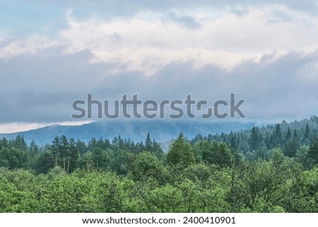 View of the Bolshaya Suka ridge from M5 highway, Chelyabinsk region, Southern Urals, Russia. Rainy foggy summer day. Dramatic landscape as abstract nature background. Forest and mountains.