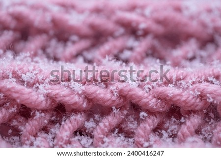 Delicate white snowflakes gently descend onto woolen knitted background, captured in mesmerizing macro detail, winter romance and natural beauty of outdoors