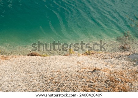 A beautiful landscape - a turquoise lake with white sand made of white chalk, left after chalk mining at the site of a chalk quarry in the city of Volkovysk