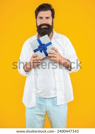 valentine man with gift box isolated on yellow. man with gift box in studio. man with gift box