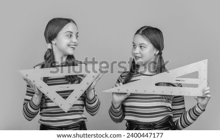 cheerful school kids hold math tool of triangle Royalty-Free Stock Photo #2400447177